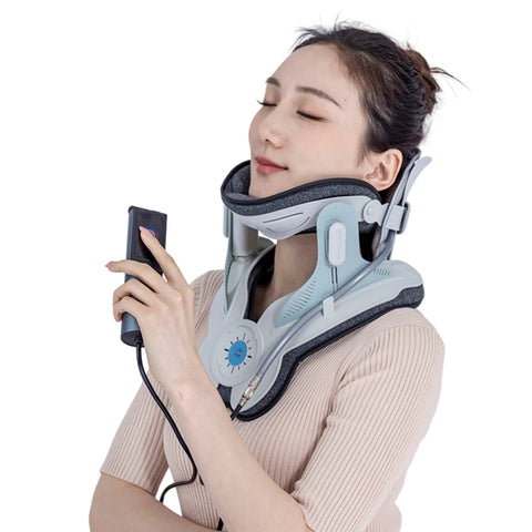 A woman wearing a light gray and black cervical collar device around her neck, holding a small black remote control against a plain light background.