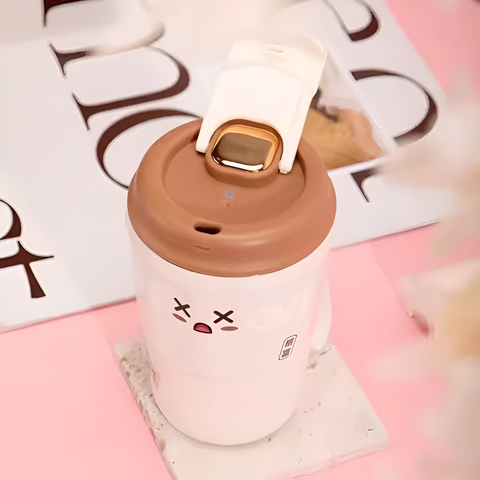 White mug with brown lid on a pink surface